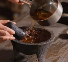 Hot oil poured over chiles in a molcajete