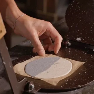 Pressing a tortilla in a tortilla press